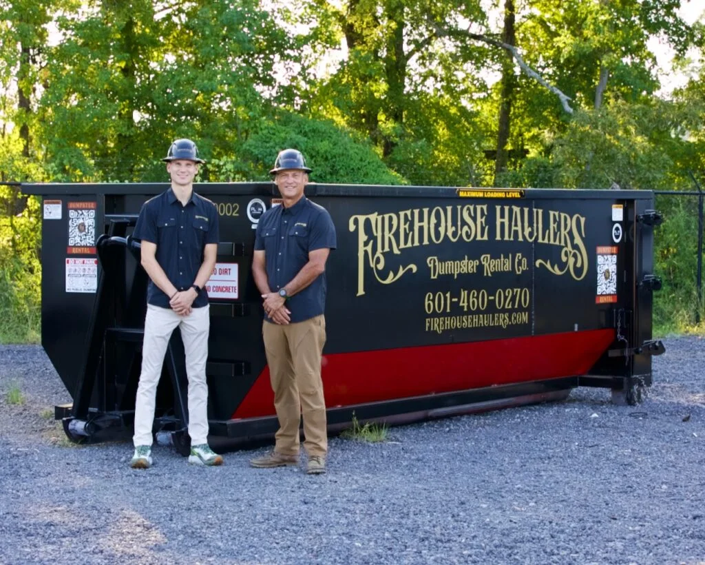 Firehouse Haulers employees standing in front of a Firehouse Haulers 20 Yard Dumpster.