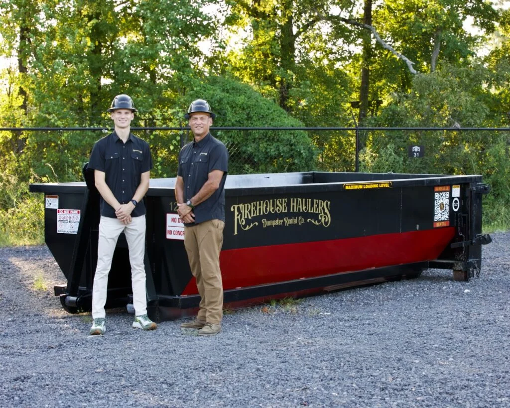 Firehouse Haulers employees standing in front of a Firehouse Haulers 12 Yard Dumpster.